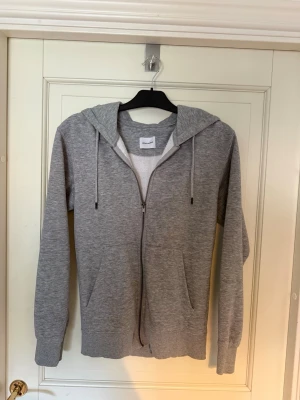 Grå hoodie med dragkedja Jack & Jones - Grå hoodie från Jack & Jones med dragkedja framtill, två fickor och med huva. Väldigt skön och har en klassisk passform. Hör av er vid funderingar. Pris kan diskuteras. Hämtas i Torslanda eller så fraktar jag.