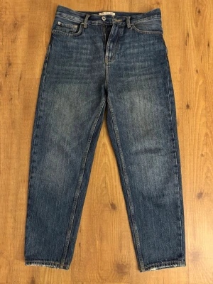 Blå raka baggy jeans från Pull&Bear - Klassiska blå jeans från Pull&Bear med rak passform. Jeansen har en snygg tvättad look och är tillverkade i denim med kontrastsömmar. Perfekta för en avslappnad och trendig stil.