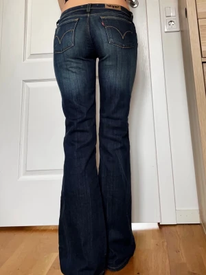 Mörkblåa Levis jeans  - Jättefina mörkblåa jeans från Levi’s i jättebra skick, i modellen 572 bootcut. Storlek W29 på lappen som motsvarar M. Midja 38cm tvärsöver, innerbenslängd 81cm 