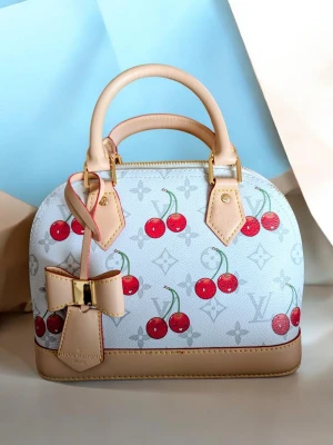 Iouis Vuitton handväska  - Supersöt vit handväsk med körsbärsmönster och beige detaljer. Väskan har en stor rosett framtill, guldfärgade metalldetaljer och röd insida. Perfekt storlek för det viktigaste och har både handtag och axelrem  .                                                                            .