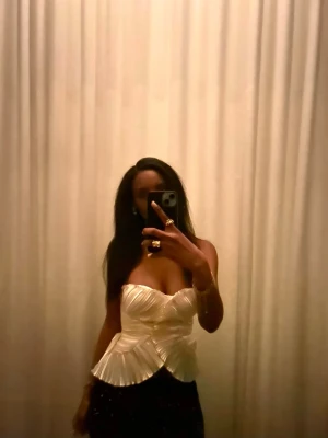 Guldig korsettopp - Säljer en snygg guldig korsettopp med draperad och veckad design. Toppen har en unik struktur med markerad midja och volangdetaljer nedtill. Perfekt för dig som vill sticka ut med en elegant och trendig look. Den är insydd vid midjan och skulle därför säga att den sitter som en xs. 