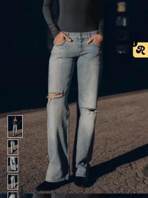 Ljusblå raka jeans med slitningar - Säljer ett par ljusblå jeans från Zara med raka ben och slitna detaljer vid knäna. Jeansen har klassisk femficksmodell, hög midja och är tillverkade i denim. Perfekta för en avslappnad och trendig look. Knappast använda. 