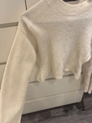 Stickad tröja gina - Vit stickad tröja, hög i halsen och utsvängd under midjan, storlek XXS men passar Xs/S, bara använd en gång💕