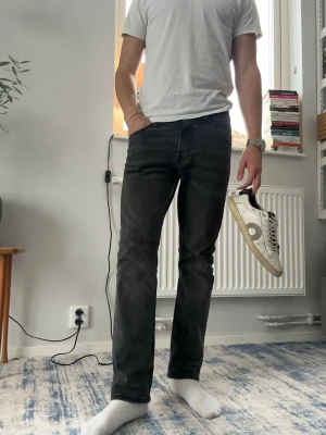 Svarta raka jeans från Lee - Säljer ett par svarta jeans från Lee med rak passform och klassisk femficksdesign. Jeansen har en något tvättad look och en skön töjbar midja som passar W30-31. Perfekta till en enkel t-shirt eller hoodie för en clean stil.                                                            Storlek W30 & L32 men har klippt ner dom så skulle säga att dom sitter närmare 31.        Hör av er vid frågor eller funderingar😊