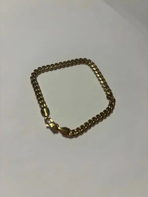 Guldigt kedjearmband - Snyggt armband i guldfärgad metall med klassisk kedjedesign och robust lås. Perfekt för dig som vill ha en stilren och tidlös accessoar som lyfter din outfit. Säljer då det inte kommer till användning. 