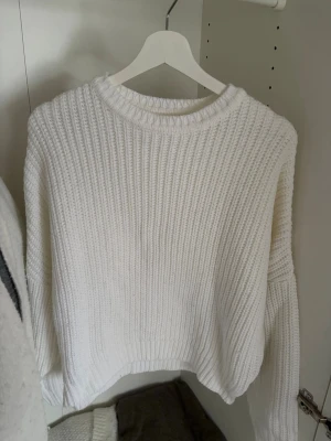 Vit stickad tröja från Even&Odd - Säljer en vit stickad tröja från Even&Odd med grov ribbstickning och rund hals. Tröjan har långa ärmar och en avslappnad passform, perfekt för att hålla sig varm under kyliga dagar. Materialet är mjukt och bekvämt.