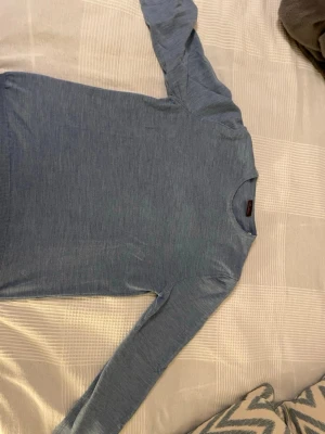 Ljusblå tröja från Stenströms - En stilren ljusblå tröja med rund halsringning och långa ärmar. Tröjan har ribbade muddar vid ärmslut och nederkant, vilket ger en snygg passform. Perfekt att matcha med jeans för en clean look.