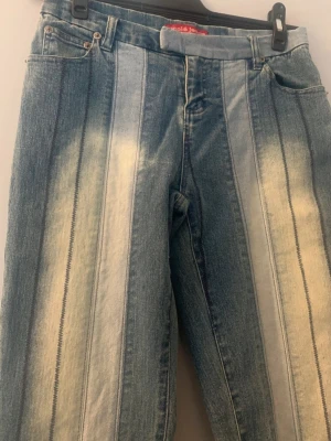 Bebeclothing. Nicole jeans. Size 10. Patchwork  - Unika patchwork jeans med breda, vertikala paneler i olika nyanser av blått och blekta detaljer. Snygg kontrastsöm längs panelerna för en cool vintagekänsla. Perfekta för dig som vill sticka ut! Size 10, bedömer som s/m. Innerbenslängd ca 79. Midja ca 77.