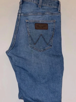 Blå jeans från Wrangler - Klassiska blå jeans från Wrangler med rak passform och säljer dom för har aldrig använt dom. De ligger bara i garderoben och tar plats och skulle säga att dom är storlek M