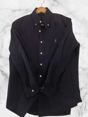 Ralph Lauren Skjorta - Mörkblå Ralph Lauren skjorta, perfekt till kommande sommaren. Storlek M. Inga deffekter. Priset är ej slaget i sten!