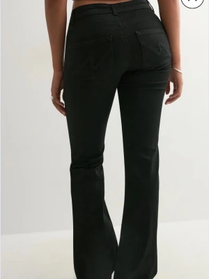 Svarta bootcut jeans från Nelly - Snygga svarta bootcut jeans från Nelly med broderade detaljer på bakfickorna. Jeansen har låg midja och är väldigt stretchiga. Storlek 44. Endast testade då de inte passa! ❤️