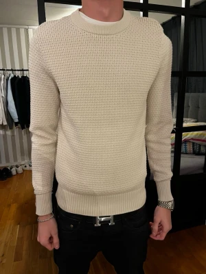 J.Lindeberg Tröja - Säljer nu min J.Lindeberg tröja, med ett mönstring material. Den är hyfsat tight med en bra passform, men kan enkelt töjas ut påtanke med materialet ifall ni nu är lite större. Tröjan är köpt i butik och har en liten defekt vid armen som ni ser på bilden.