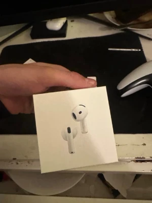 Airpods 4 - Säljer ett par vita Apple AirPods 4 med trådlöst laddningsetui. Snygg och stilren design i blank plast, perfekt för dig som vill ha grymt ljud och smidig anslutning till iPhone eller andra Apple-enheter. Kommer i originalförpackning med tillbehör.