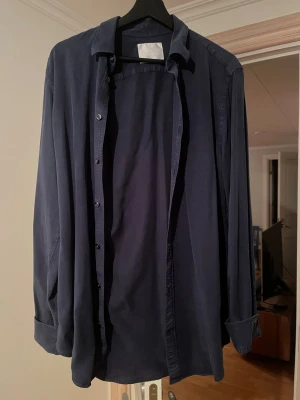 Mörkblå skjorta Oscar Jacobson - Snygg mörkblå skjorta i otroligt mjukt och skönt material! ALDRIG ANVÄND!Perfekt att bära öppen över en t-shirt eller stängd för en mer uppklädd look. Storlek S men passar dig som är 185+