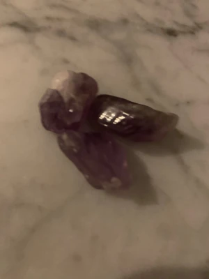 Råa ametiststenar lila - Säljer flera råa ametiststenar i vacker lila nyans. Stenarna har oregelbunden form och naturlig yta, perfekta som dekoration eller för att använda i smyckestillverkning. Ingen slipning eller hål, bara naturliga kristaller.