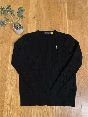 Ralph Lauren stickad svart  - Fin Ralph Lauren tröja, är i princip ny bara använd 2-3 gånger och testad därför säljer jag den billigt, är lite liten i storlek står S men passar bättre XS. Skriv om ni har några frågor😊