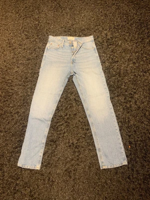 Jack and Jones ljusblå jeans, storlek 27/30 - Ljusblå Jack and Jones jeans med klassisk rak passform och knappgylf. Modellen har fem fickor och är tillverkad i slitstarkt bomullsjeans. Perfekt för dig som gillar tidlös denimstil och vill ha ett par raka jeans med hög midja. Hör av dig vid minsta fundering eller fråga och pris kan diskuteras! 🤩🙌
