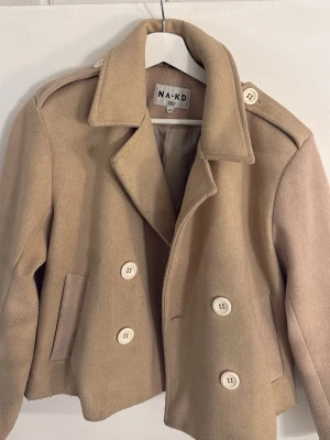 Beige kappa - Snygg beige kappa från NA-KD i storlek 36