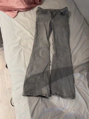 Gråa utsvängda jeans -  Säljer mina gråa låg midjade jeans från lager 157 i storlek XS 