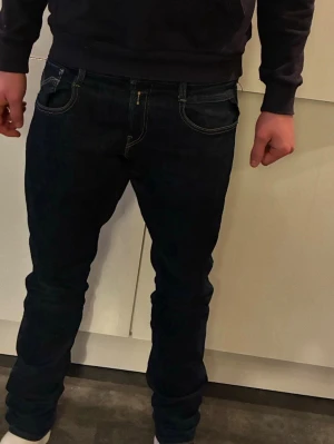 Mörkblå replay jeans herr i storlek 30/34 - Snygga mörkblå  anbass style lot jeans från replay med klassiska fem fickor och kontrastsömmar. Jeansen har en modern passform som sitter tajt längs benen och är tillverkade i ett stretchigt denimtyg för extra komfort. Perfekta för en trendig och avslappnad stil. Köpta från mq 