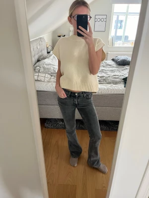 Grå bootcut jeans med vintage-look - Säljer ett par grå bootcut jeans med klassisk femficksdesign och snygg vintage-tvätt. Jeansen har normal midja och är tillverkade i ett mjukt denim-material som ger en skön passform. Perfekta för dig som gillar en avslappnad och trendig stil.