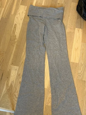 Grå bootcut leggings Gina Tricot - Snygga grå Yoga panta från Gina Tricot med bootcut-ben och bred linning. Tillverkade i mjukt stretchigt material som sitter skönt på kroppen. Perfekta för en avslappnad och trendig look. Helt oavända dock ej prislapp kvar!🤍