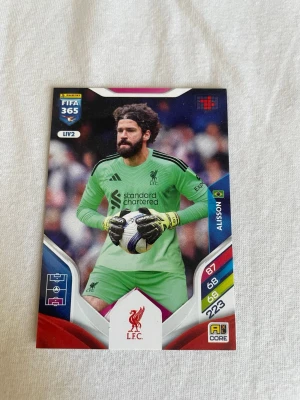 Panini FIFA 365 Adrenalyn XL samlarkort - Panini FIFA 365 Adrenalyn XL samlarkort med motiv av en målvakt från Liverpool FC. Kortet har gröna, röda och blå detaljer samt spelarstatistik på framsidan. Baksidan innehåller en aktiveringskod för online-spel. Perfekt för samlare av fotbollskort.