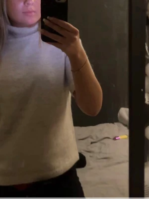 En beige stickad tröja med lite högre hals - Jag säljer en beige stickad kortärmad tröja med lite högre hals, den är i bra skick och använd få tal gånger😊