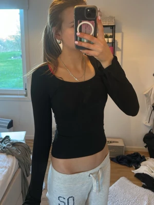 Svart långärmad topp med tight passform - Säljer en svart långärmad topp med tight passform och rundad halsringning. Toppen är enkel och stilren, perfekt att matcha med olika outfits. Materialet känns mjukt och stretchigt, vilket gör den bekväm att bära.💞