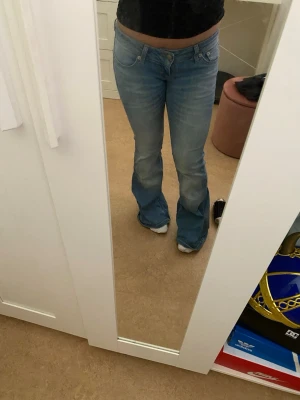 Ljusblå blaze jeans - I storlek XS/SHORT, ljusblå bootcut jeans med klassisk femficksdesign och låg midja. Jeansen har en lätt utsvängd passform nertill och är tillverkade i denim. Perfekta för en avslappnad och trendig look. PRISET KAN DISKUTERAS!❤️