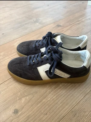 Mörkblå sneakers från Stockholm Design - Snygga mörkblå sneakers i mocka med vit detalj och gummisula. Klassisk låg modell med vita och blå detaljer, samt snörning framtill. Perfekta för dig som gillar stilrena och tidlösa skor med en sportig touch. Använda lite men fortfande i bra skick 