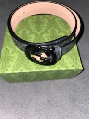 Svart skärp med GG-spänne från Gucci - Snyggt svart bälte från Gucci med klassiskt GG-spänne i svart metall. Du får med Gucci påse. Gucci autentisk kort, kvitto och box. Om du har några funderingar skicka ett meddelande.