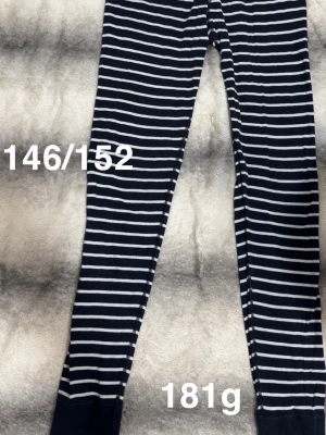 Randiga leggings i marinblått och vitt - Snygga leggings med marinblå och vita horisontella ränder. De har en smal passform och är perfekta för en avslappnad stil. Mjukt och stretchigt material som sitter skönt hela dagen.🌸 Fint använt skick. Storlek 146/152