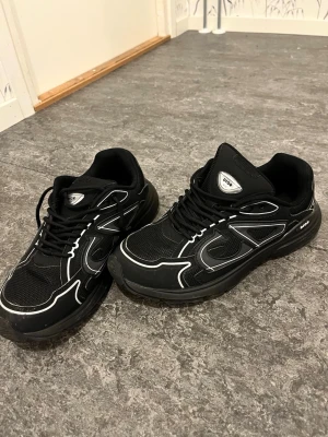 Dior skor använder inte dom längre är nya har använt dom några gånger ba - Snygga svarta sneakers från Dior med vita kontrastdetaljer och meshpaneler för extra ventilation. Skorna har en chunky sula och klassisk snörning. Perfekta för dig som vill ha en stilren men ändå sportig look. Dior b30