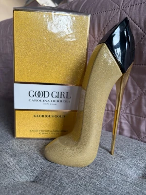 Good Girl Glorious Gold parfym - Good Girl Glorious Gold från Carolina Herrera är en lyxig parfym i en unik flaska formad som en stilettklack. Flaskan är täckt av guldglitter med svart och gulddetaljer, vilket ger en glamorös känsla. Perfekt för dig som älskar exklusiva dofter och snygg design.