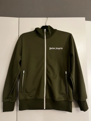 Palm Angels tröja grön - Snygg olivgrön ziptröja från Palm Angels, används inte längre och är i ny-skick! Går ej att köpa på nätet längre. Äkta, la in en bild så man kan kolla det också😁 kvitto finns vid intresse av köp. Prutbart
