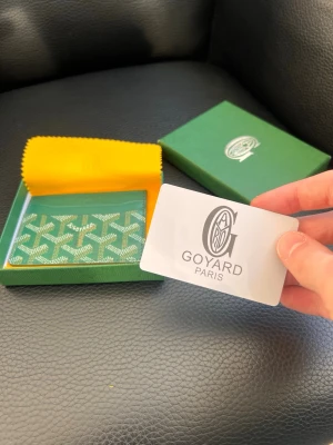 Grön korthållare  - Snygg grön korthållare med det klassiska vita och gröna mönstret. Tillverkad i canvas och läder, perfekt för kort och ID. Kommer med original ask och tygpåse. En riktigt stilren accessoar för dig som gillar exklusiva detaljer.