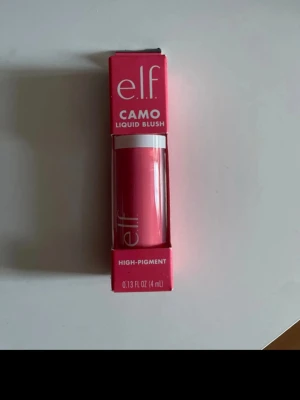 e.l.f. Camo Liquid Blush Pinky Promise - e.l.f. Camo Liquid Blush i färgen Pinky Promise. Ett flytande rouge med hög pigmentering i en intensiv rosa nyans. Kommer i en smidig tub på 4 ml, perfekt för att skapa en fräsch och naturlig look. Förpackningen är rosa med vit text.