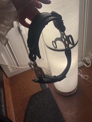 Svart lädergrimma hackamore  - Säljer en svart grimma i läder med detaljer i silverfärgad metall. Grimman har justerbara spännen och robusta beslag på sidorna. Passar till häst eller ponny och är både snygg och funktionell.