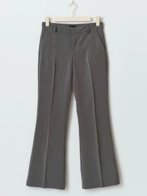 Grå kostymbyxor från GinaTricot - Snygga petit grå kostymbyxor med pressveck och utsvängda ben. Byxorna har hällor för skärp, snedställda fickor fram och stängs med dragkedja och hake. Perfekta för en stilren och modern look. 