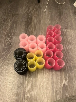 Papiljotter - Säljer ett set med självhäftande hårspolar i olika storlekar och färger: rosa, svart, gul och röd. Perfekta för att skapa volym och lockar utan värme. De flesta är från normal