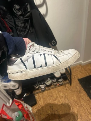 Vita sneakers från Valentino  - Säljer ett par vita sneakers från Valentino.  Skorna har vita snören, nitar på hälen och är tillverkade i läder. Snygg och stilren design som passar till många outfits. Dem här även lite slit märke på tårna men inget man tänker på. Vid frågor hör gärna av er. Obs! Box å kvitto försvann i flytten 