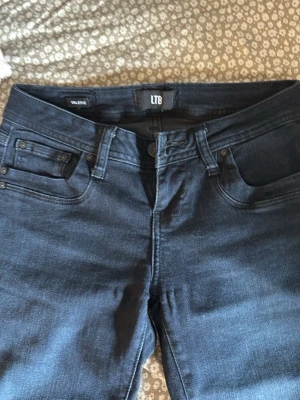 Mörkblå jeans från LTB - Snygga mörkblå jeans från LTB med klassisk femficksdesign och utsvängda ben. Jeansen har en diskret tvätt och är tillverkade i mjukt denim-material som ger en skön passform. Perfekta för dig som gillar stilrena och tidlösa jeans. 💘