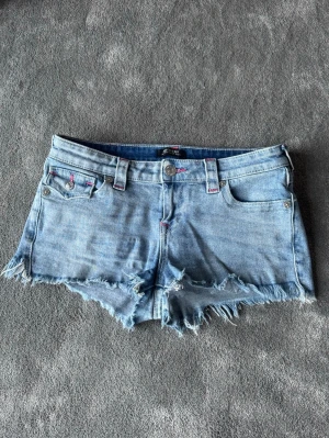 Low waist True Religion shorts - Sälja dessa snygga ljusblå short med rosa detaljer från True Religion som är lågmidjade 🩷 Knappt använda, säljer pga att jag aldrig använder dem. Dem är även slutsålda hos Nelly. Skriv om intresserad eller frågor💕(Det står storlek 28, skulle säga de e samma som storlek M)