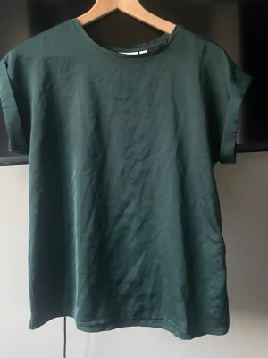 Mörkgrön oversized t-shirt - En stilren mörkgrön båt ringad oversized t-shirt med rund halsringning och korta ärmar. Tillverkad i mjukt silkestyg på framsidan och bomullstyg på baksidan. Har aldrig använts. Storlek 34 men är oversixed så passar större ❣️