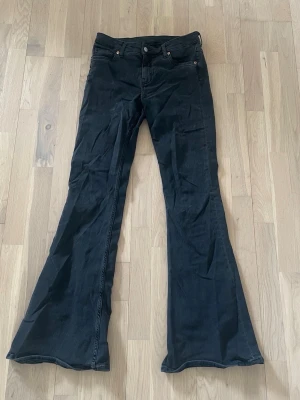 Svarta jeans - Säljer dessa svarta mid waist bootcut jeans från Monki. Dom är i storlek S. Passar folk som är längre men går ju även att klippa av för att få kortare. Liten vit fläck på ena fickan (som man ser på bilden)