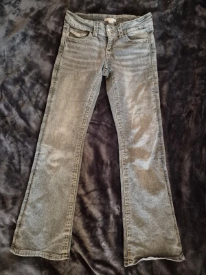 Grå jeans - Grå jeans med knappar på fickorna. Storlek 152.