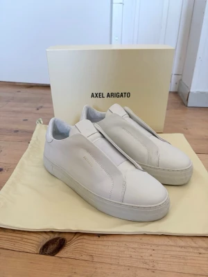 Axel Arigato Laceless - Arigato Clean Laceless 360 i vitt läder. Använda endast två gånger. Allt original följer med. Storlek 41. Köpt via Axel Arigatos hemsida för 2800kr.