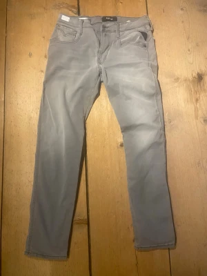 Gråa slim fit jeans från Replay  - Säljer ett par gråa slim fit jeans från Replay med klassisk femficksdesign och raka ben. Jeansen har en modern passform och är tillverkade i ett mjukt denim-material som ger en skön känsla. Perfekta för dig som gillar stilrena och enkla jeans.
