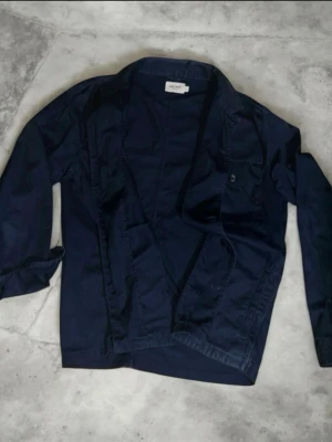 East west overshirt - Denna overshirt erbjuder en förfinad version av vardagsklädsel och är ett mångsidigt tillskott till varje garderob. Designen kompletteras med praktiska bröstfickor och en klassisk polokrage, vilket garanterar både stil och funktionalitet. 